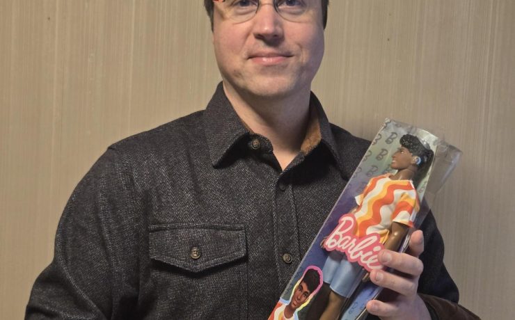 A person holding a doll that has a hearing aid