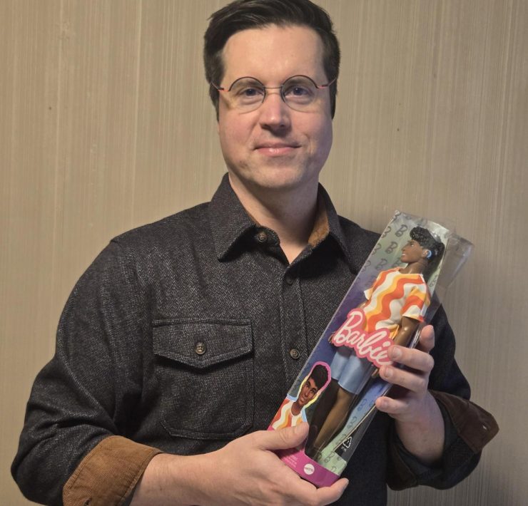 A person holding a doll that has a hearing aid
