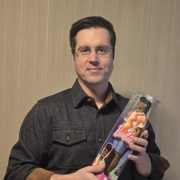A person holding a doll that has a hearing aid