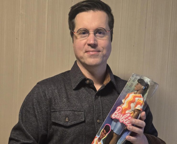 A person holding a doll that has a hearing aid