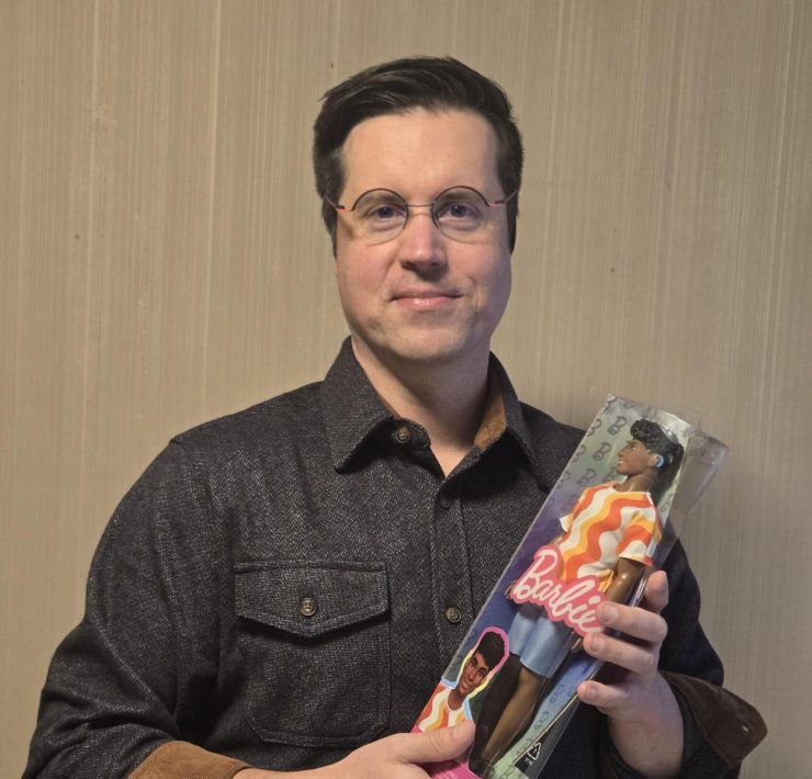 A person holding a doll that has a hearing aid