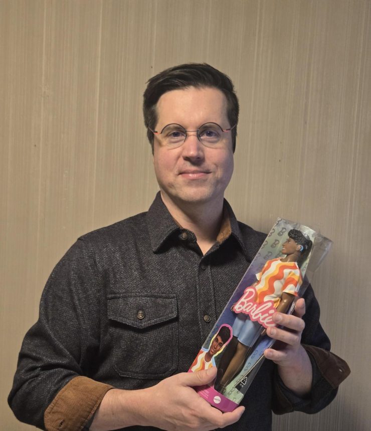 A person holding a doll that has a hearing aid